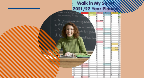 This image shows a female teacher at the desk with a copy of the Walk in My Shoes Year Planner in the background