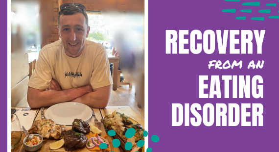 Photo of Cormac Ryan in a restaurant in Argentina, with plates of grilled meats on the table in front of him